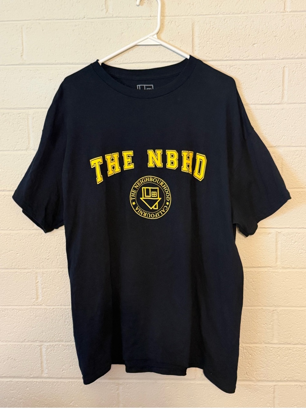 The NBHD Short Sleeve Logo Tee in Black with Yellow Print